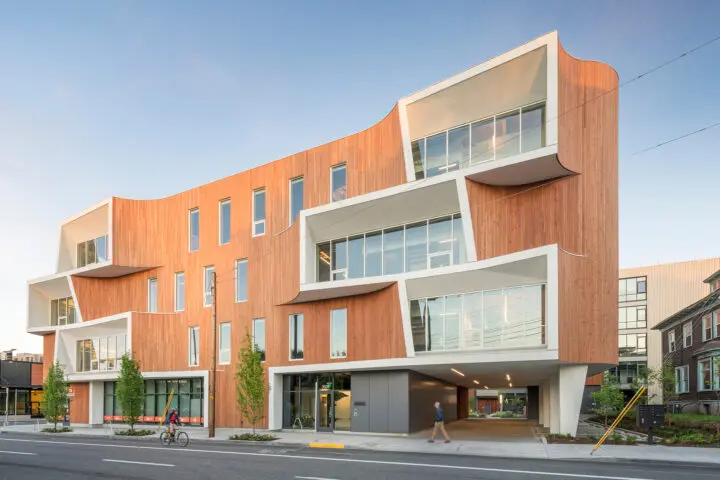 A small driveway and parking access are nestled under the northeastern corner of the building, which opens to the courtyard beyond.