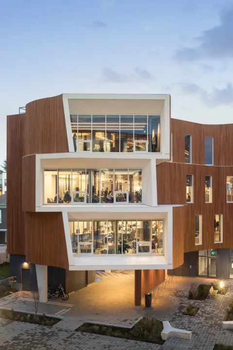 An aerial view from the third floor level looks into the floor-to-ceiling window apertures in the office spaces.
