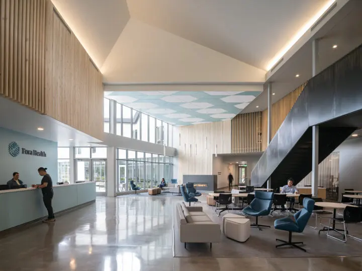 The lobby is framed by a recessed reception and dark metal stair.