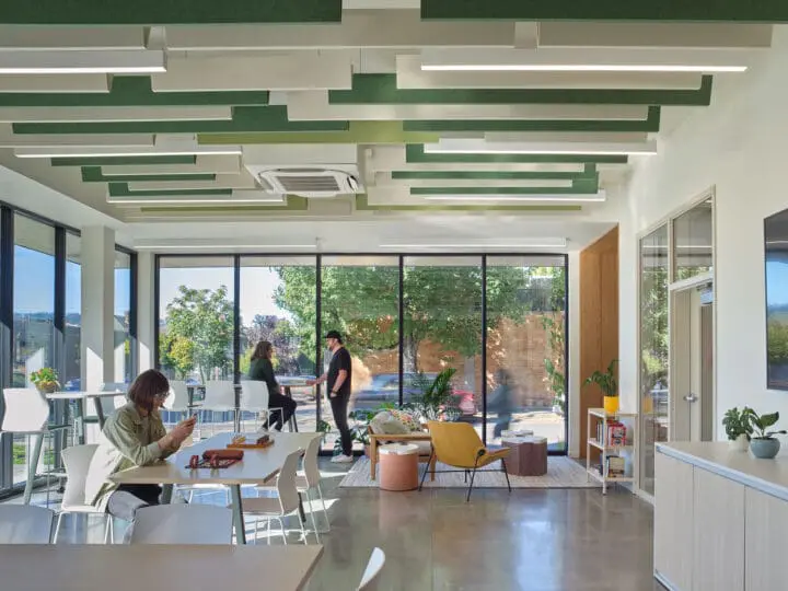A living room-like space in the community room is defined by couches and a rug.