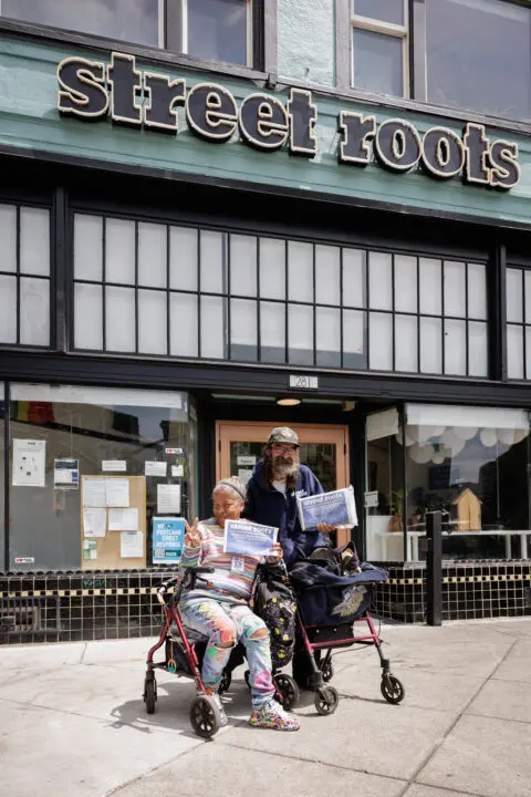 Two team members with walkers strike a pose at the front entrance.