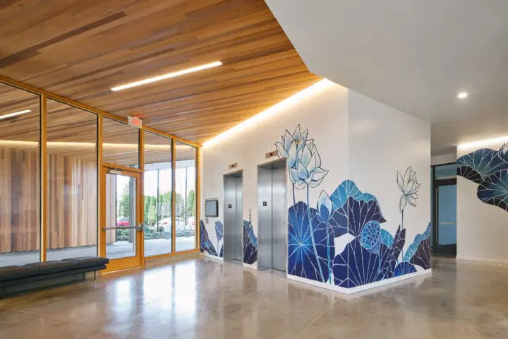 View of the elevators in the lobby, which are surrounded by the blue floral mural.