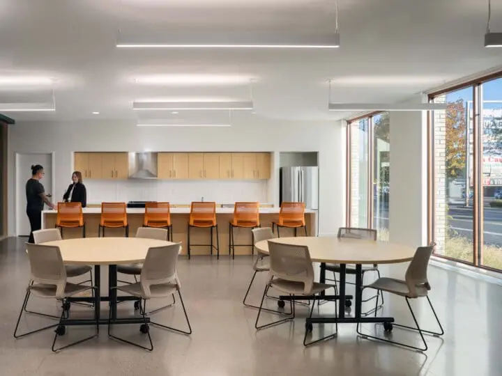 Two people stand at the island in the community room's kitchen at The Aurora.